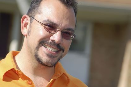 A man wearing an orange polo shirt with orange sunglasses