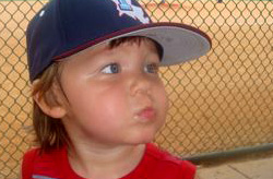 Toddler boy wearing baseball cap looking off camera