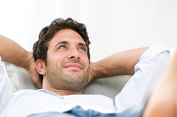 Happy man relaxing on a sofa.          