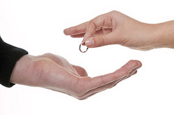 A woman handing her wedding ring over to her former husband