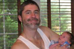 Infant held in smiling father's arms