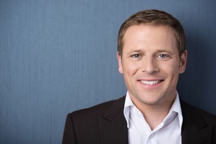 A young man with a dress shirt and sports coat