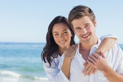 Smiling man and woman on the beach.          