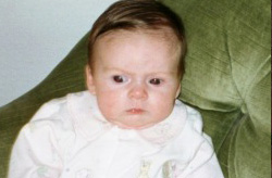 Baby looking off camera propped in chair